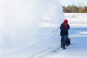 Person operating a snow blower